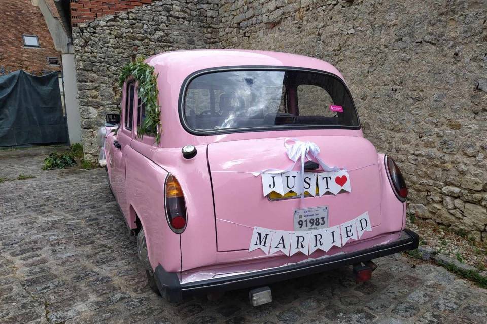 Taxi anglais rose avec mariés