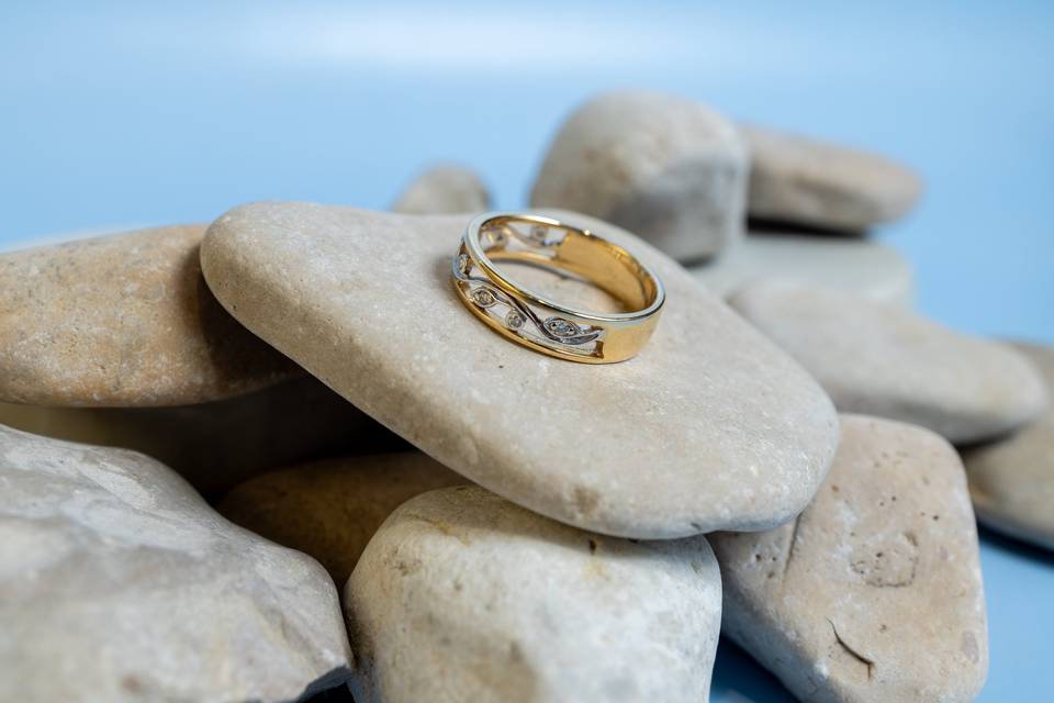 bague or ciselle sur galet blanc