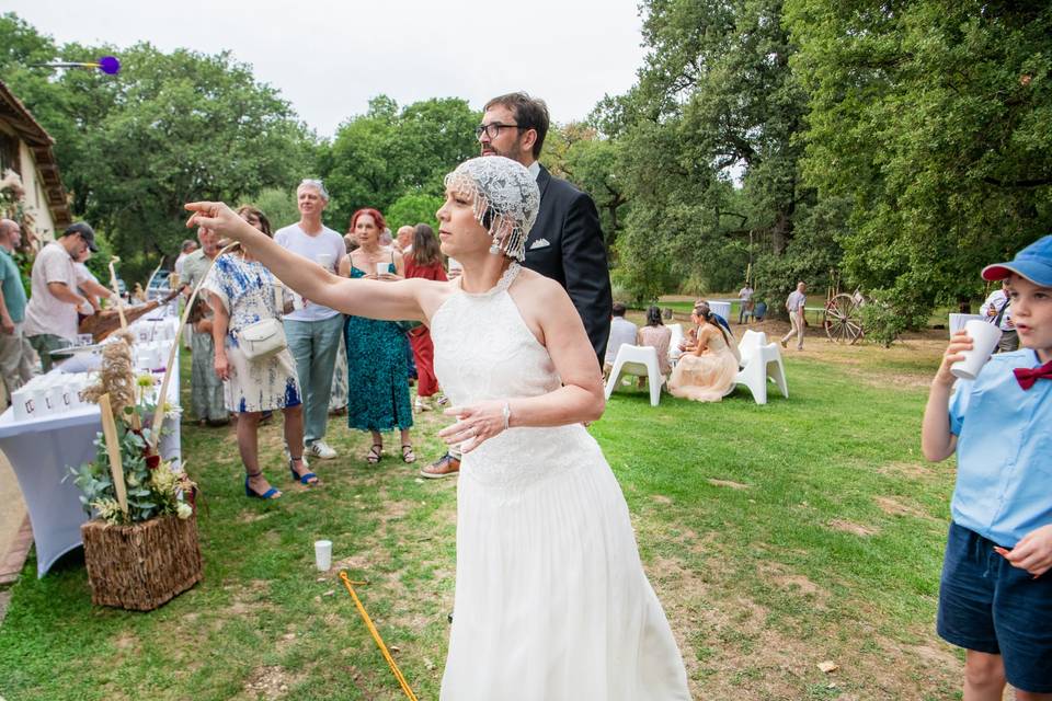 Mariée lançant fléchette jardin