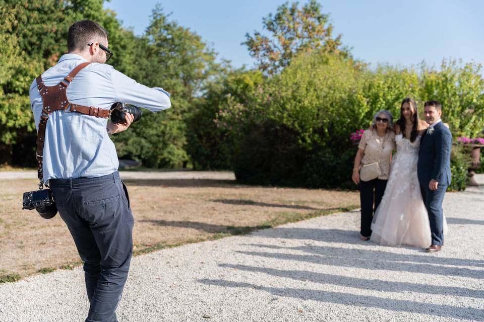 Photographe photographiant un couple au loin sur la pelouse