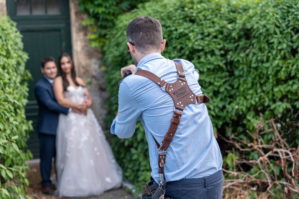 Vue de dos du photographe cadrant le couple dans un cadre de verdure