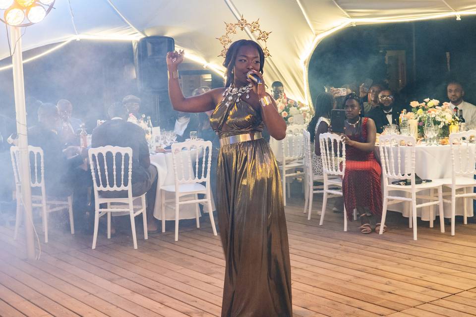 Chanteuse en robe dorée interprétant un titre