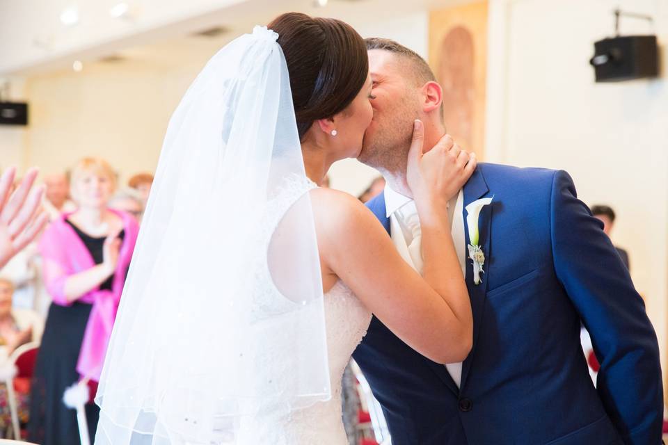 Baiser des mariés entourés des invités