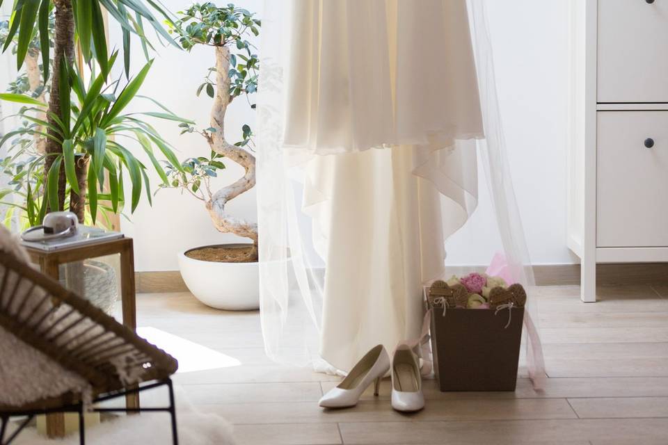 Robe de mariée suspendue près d'une plante verte