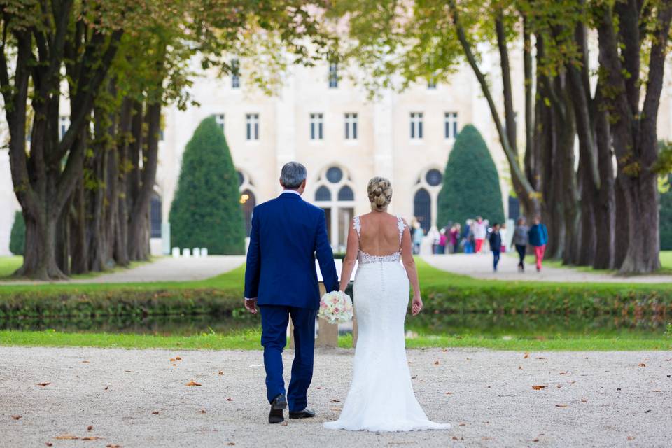 Mariés sur une allée bordée d'arbres
