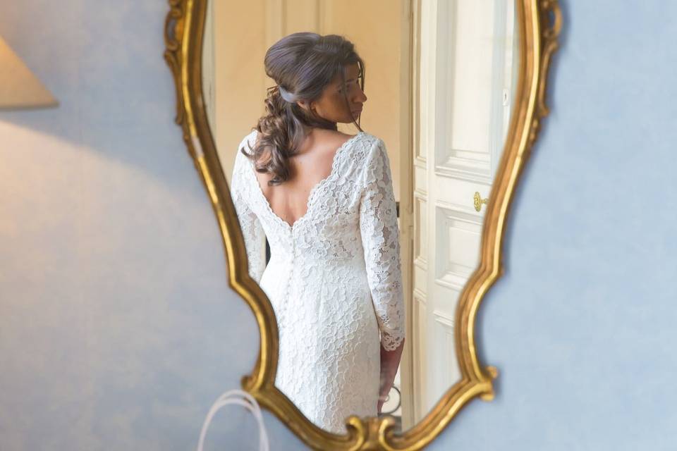 Robe de mariée suspendue à un miroir doré