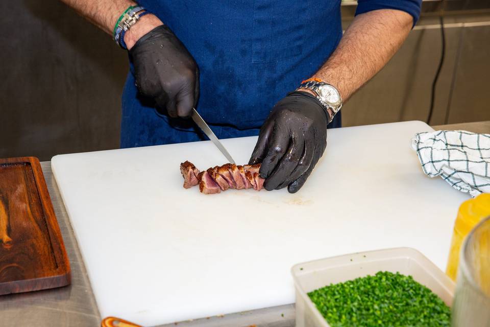 chef découpant la viande sur planche blanche