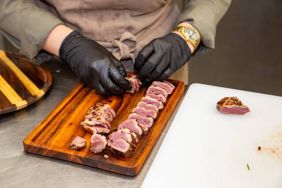 mains préparant du bœuf sur bois