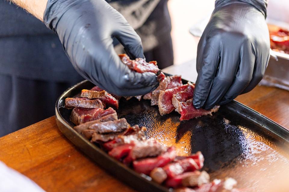 Chef coupant un steak grillé en lanières