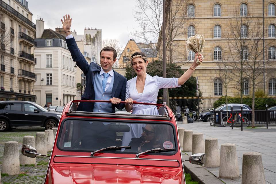 Mariée et marié dans une voiture rouge